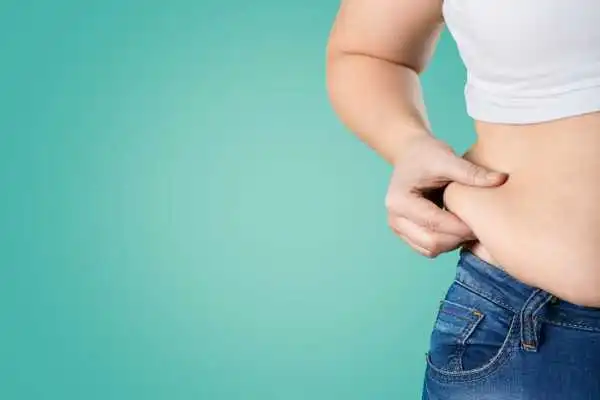 Image of woman pinching her love handles to show weight gain Norwich